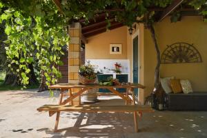 a wooden picnic table in front of a house at Country House With Pool Among Noto Citrus Groves in Noto