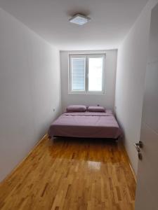 a bedroom with a bed and a window at Pantelej gates in Niš