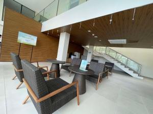 a lobby with chairs and tables and a staircase at Reflective Woodscape- 1 Bedroom with Balcony in Bacolod