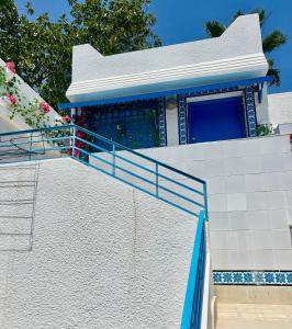 a house with blue and white tiles on the stairs at Hammamet Studio Hafsya in Hammamet