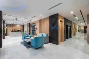 a lobby with a blue couch and chairs in a building at Renium Hotel Jazan in Jazan