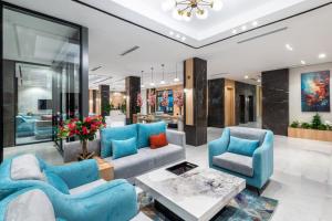 a living room with blue chairs and a table at Renium Hotel Jazan in Jazan
