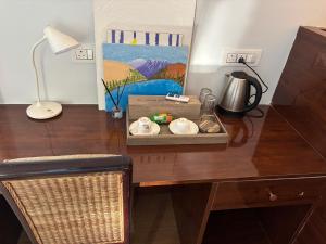 a desk with a lamp and a plate on it at LA Mili A Luxury Homestay in North Lakhimpur +20 photos