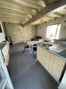 a kitchen with a sink and a table in a room at Joli petit gîte in Montferrer