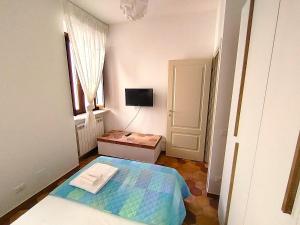 a small bedroom with a bed and a television at B&B dell'Arco in LʼAquila