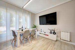 ログローニョにあるApartamento Momentos by Clabaoの白いダイニングルーム(テーブル、テレビ付)