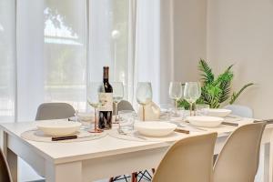 ログローニョにあるApartamento Momentos by Clabaoの白いダイニングルームテーブル(ワインボトル、グラス付)