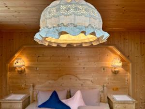 a chandelier above a bed in a wooden room at Haus Erika in Stummerberg