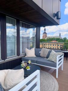 a living room with a couch and a table on a balcony at Quality Hotel Grand Falun in Falun