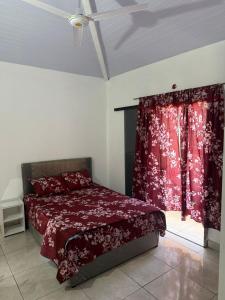 a bedroom with a bed with red sheets and a window at EmiQuinta depto 1 in Cambyretá