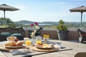 a table with food and orange juice on a balcony at U Paesolu in Sainte-Lucie de Porto-Vecchio