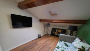 a living room with a couch and a flat screen tv at City Garden Villa , Ponta Delgada in Ponta Delgada