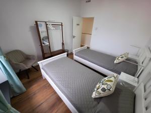 a small room with two beds and a mirror at City Garden Villa , Ponta Delgada in Ponta Delgada