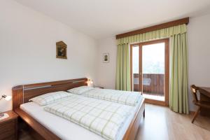 ein Schlafzimmer mit einem Bett und einem großen Fenster in der Unterkunft Ciasa Saina in Wengen