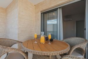 a wooden table with four chairs and orange juice at Villa Anida in Ulcinj