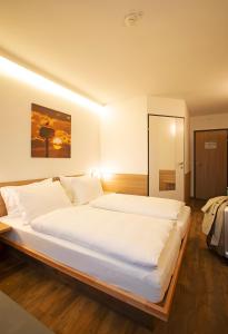 a bedroom with a large white bed in it at OEKOTEL Hohenems in Hohenems
