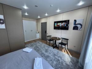 a bedroom with a bed and a table and a tv at Damir HOTEL ГОСТИНИЦА in Aktobe