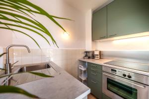 a kitchen with green cabinets and a sink at Villetta Allegra in Appiano sulla Strada del Vino +11 photos