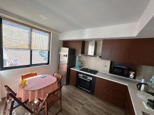 a kitchen with a table and a kitchen with a stove at Amplio, Familiar y Acogedor in Cochabamba