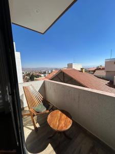 a balcony with a wooden chair and a table at Amplio, Familiar y Acogedor in Cochabamba