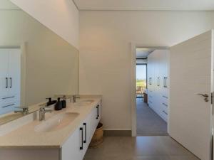 un bagno bianco con due lavandini e uno specchio di St Francis Links - Villa Avenue Studio Apartments a St Francis Bay Altre 203 foto