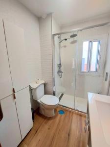 a white bathroom with a toilet and a shower at San Pagés 3BR Apartment in Seville