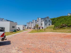 un vialetto di mattoni con case sullo sfondo di St Francis Links - Villa Avenue Studio Apartments a St Francis Bay