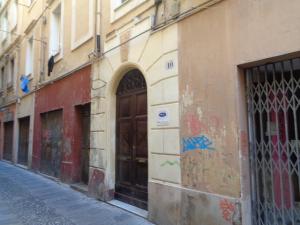 an alley with a brown door on the side of a building at Monte Longu in Sassari