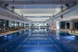 a large swimming pool with chairs in a building at Donnington Hotel, Spa & Golf in Newbury