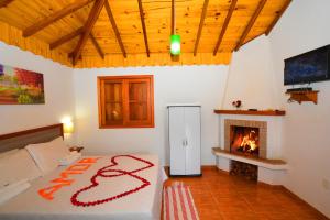 a bedroom with a bed and a fireplace at Pousada Cantinho Colibri in Monte Verde