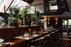 a row of tables in a restaurant with plants at Donnington Hotel, Spa & Golf in Newbury