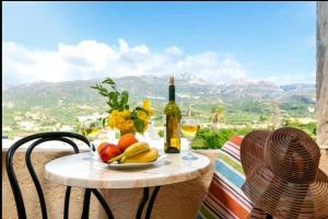 a table with a plate of fruit and a bottle of wine at Tolles Ferienhaus In Piskokefalo Mit Terrasse in Piskokéfalon +16 photos