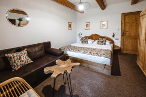 a bedroom with a bed and a leather couch at Hotel Frýdl in Prague