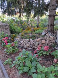 a garden with flowers and a rock wall at Dworek Biała Dama Klimatyczne Pokoje in Gniezno