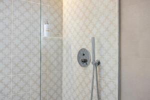 une douche avec une porte vitrée dans une salle de bain dans l'établissement Anita Rooms, à Olbia