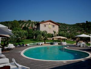 a swimming pool with chairs and a house in the background at Agriturismo Casale Ré in Sonnino