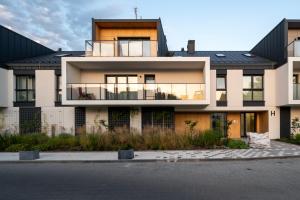 a large house with a black roof at Rąbieńska Urban Elegance Apartment by BookingHost in Łódź