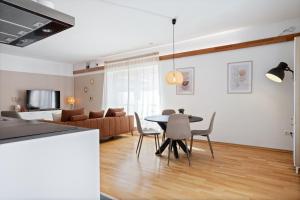 ハーレンにあるAurora Sauna Suite, waar rust comfort en een vleugje luxe samenkomenのテーブルと椅子とソファのあるリビングルーム