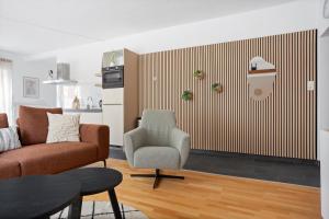 ハーレンにあるAurora Sauna Suite, waar rust comfort en een vleugje luxe samenkomenのソファと椅子のあるリビングルーム