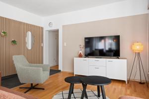 a living room with a tv and a chair and a table at Aurora Sauna Suite, waar rust comfort en een vleugje luxe samenkomen in Haren