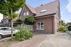 a brick house with a car parked in front of it at Aurora Sauna Suite - Moderne Ferienwohnung mit Sauna - nur 10 Minuten von Schloss Dankern in Haren