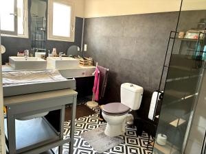 a bathroom with two sinks and a toilet at villa de canet 66 in Canet-en-Roussillon +18 photos