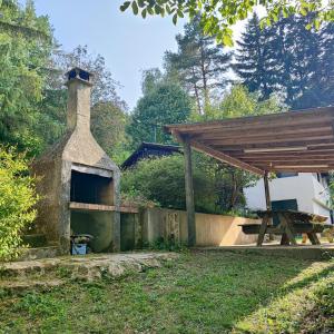 een buitenoven en een picknicktafel in een tuin bij Chalet atypique in Anglès