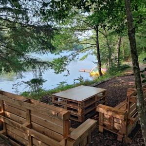 een picknicktafel en banken naast een meer bij Chalet atypique in Anglès +3 foto's