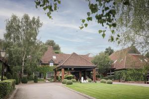 a house with a yard with a driveway at Donnington Hotel, Spa & Golf in Newbury