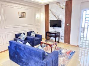 a living room with two blue couches and a tv at Full Moon House in Luxor