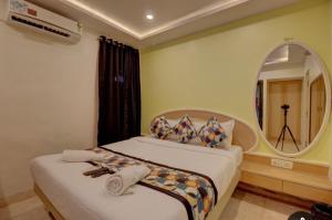 una habitación de hotel con una cama y un espejo en Hotel Stay Land Inn Versova, en Bombay