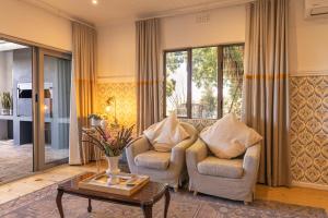 a living room with two chairs and a coffee table at Fransmanskraal Accommodation - Farm Cottage in Stellenbosch