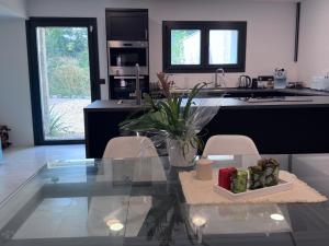 a kitchen with a glass table and a counter top at Quiet village house in L’ Esquirol +8 photos