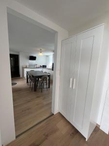 a living room with a table and a dining room at Maison cosy - salle de jeux, cinéma et jacuzzi in Ittenheim